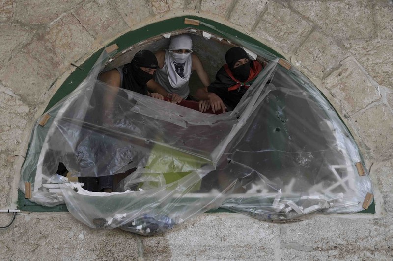 Palestinians clash with Israeli security forces at the Al Aqsa Mosque compound in Jerusalem's Old City Friday, April 15, 2022. (AP Photo/Mahmoud Illean)