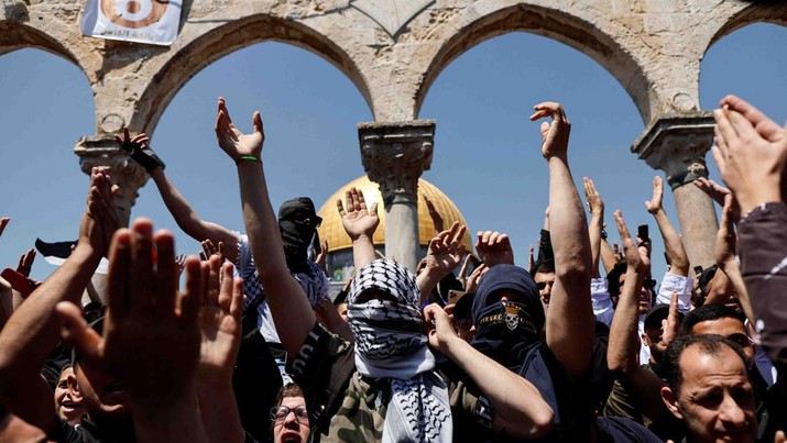 Palestinians shout slogans at the compound that houses Al-Aqsa Mosque, known to Muslims as Noble Sanctuary and to Jews as Temple Mount, following clashes with Israeli security forces in Jerusalem's Old City April 15, 2022. REUTERS/Ammar Awad