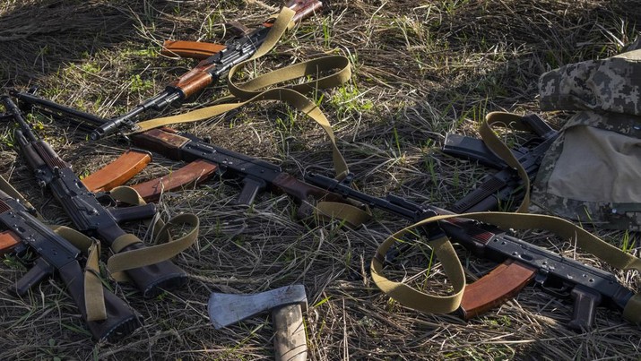 Senapan dan kapak tergeletak di lapangan tempat tentara Ukraina menggali parit jika terjadi invasi Rusia lainnya, di Bucha, di pinggiran Kyiv, Ukraina. (AP/Rodrigo Abd)