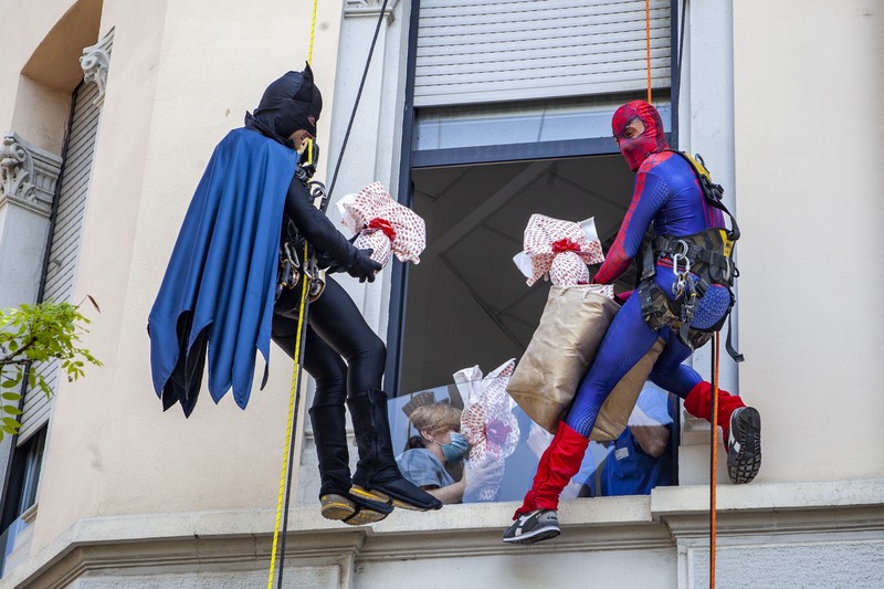 Batman and Spiderman climb down the facade to deliver chocolate eggs for Easter to the children hospitalized in the De Marchi Pediatric Clinic in Milan, Italy, Thursday, April 14, 2022. (LaPresse via AP)