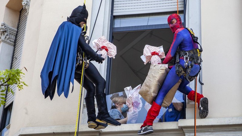 Batman and Spiderman climb down the facade to deliver chocolate eggs for Easter to the children hospitalized in the De Marchi Pediatric Clinic in Milan, Italy, Thursday, April 14, 2022. (LaPresse via AP)