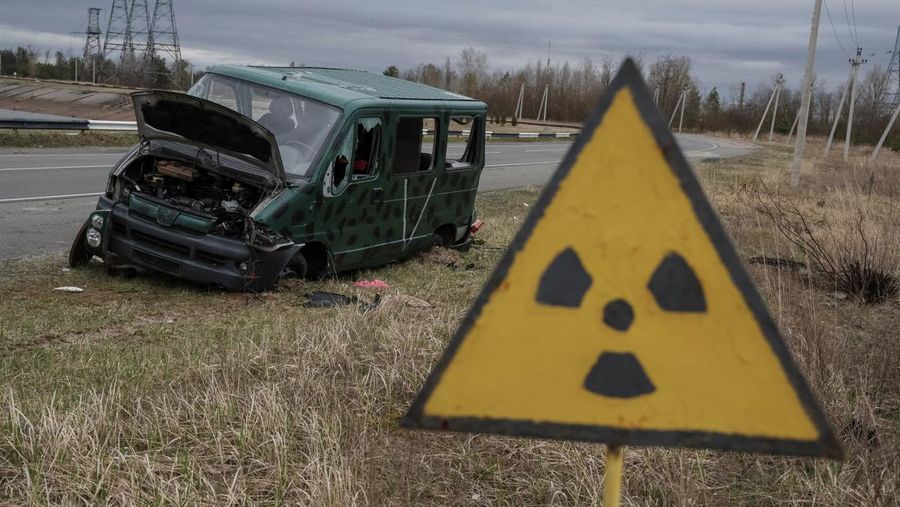 A destroyed car marked with the letter ''V'' is seen near the New Safe Confinement (NSC) structure over the old sarcophagus covering the damaged fourth reactor at the Chornobyl Nuclear Power Plant, in Chornobyl, Ukraine April 16, 2022. REUTERS/Gleb Garanich