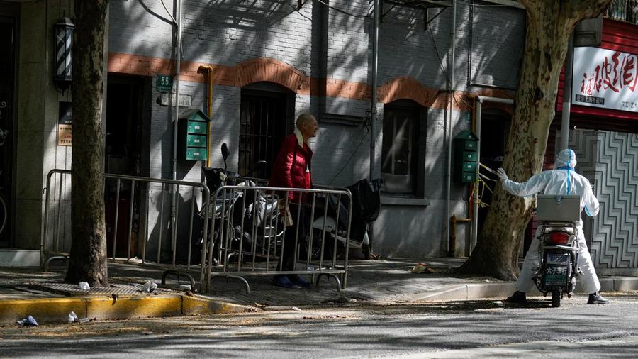 A worker in protective suit talks with a resident at a residential area under lockdown amid the coronavirus disease (COVID-19) pandemic, in Shanghai, China April 17, 2022. REUTERS/Aly Song