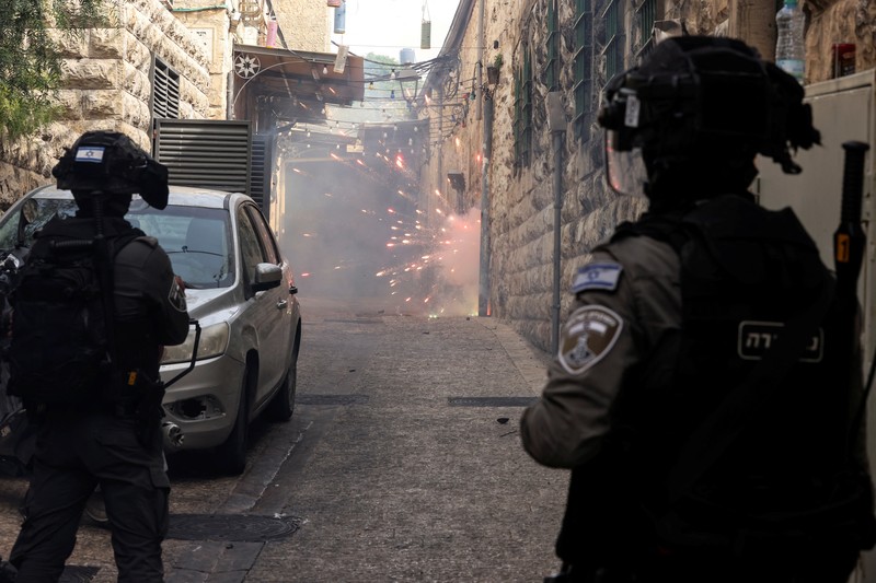 ISRAEL-PALESTINIANS/VIOLENCE Israeli Border police officers run in an alley in Jerusalem's Old City April 17, 2022. REUTERS/Ammar Awad