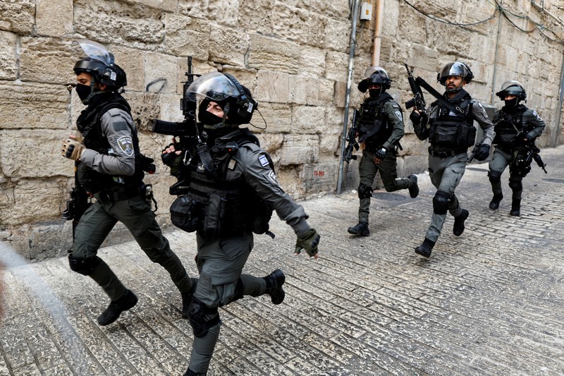 ISRAEL-PALESTINIANS/VIOLENCE Israeli Border police officers run in an alley in Jerusalem's Old City April 17, 2022. REUTERS/Ammar Awad