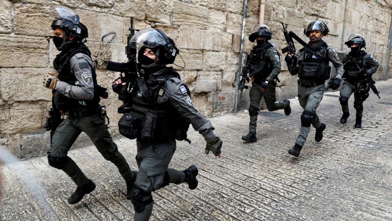 Israeli Border police officers run in an alley in Jerusalem's Old City April 17, 2022. REUTERS/Ammar Awad