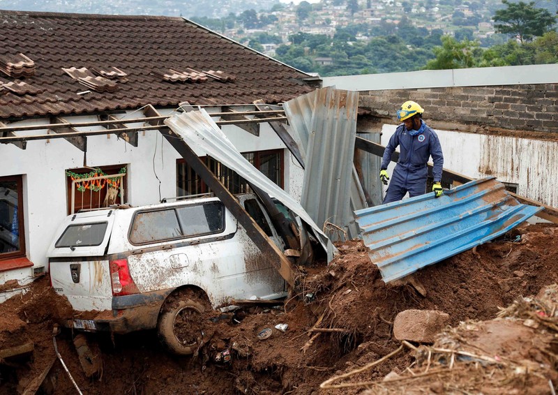 SAFRICA-FLOODS/ A search and rescue team member uses a dog to search for bodies in Dassenhoek near Durban, South Africa, April 17, 2022. REUTERS/Rogan Ward