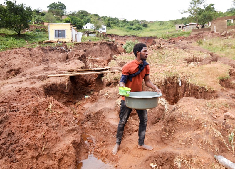SAFRICA-FLOODS/ A search and rescue team member uses a dog to search for bodies in Dassenhoek near Durban, South Africa, April 17, 2022. REUTERS/Rogan Ward