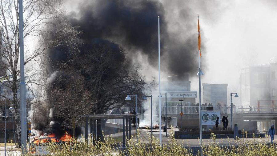 Smoke billows from a burning car during a riot ahead of a demonstration planned by Danish anti-Muslim politician Rasmus Paludan and his Stram Kurs party, which was to include a burning of the Muslim holy book Koran, in Navestad, Norrkoping, Sweden April 17, 2022, in this handout image obtained by Reuters on April 17, 2022.       Ulf Wigh/Wighsnews/Handout via REUTERS    THIS IMAGE HAS BEEN SUPPLIED BY A THIRD PARTY. MANDATORY CREDIT.