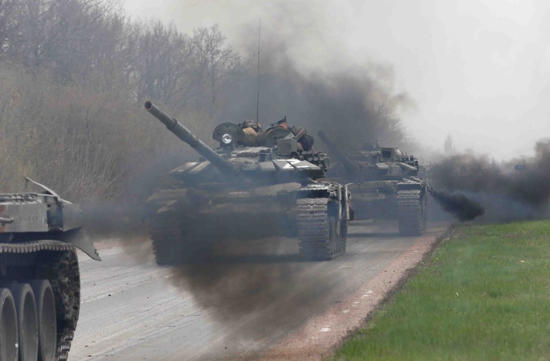Service members of pro-Russian troops and civilians sit atop of an armoured vehicle during Ukraine-Russia conflict in the southern port city of Mariupol, Ukraine April 17, 2022. REUTERS/Alexander Ermochenko