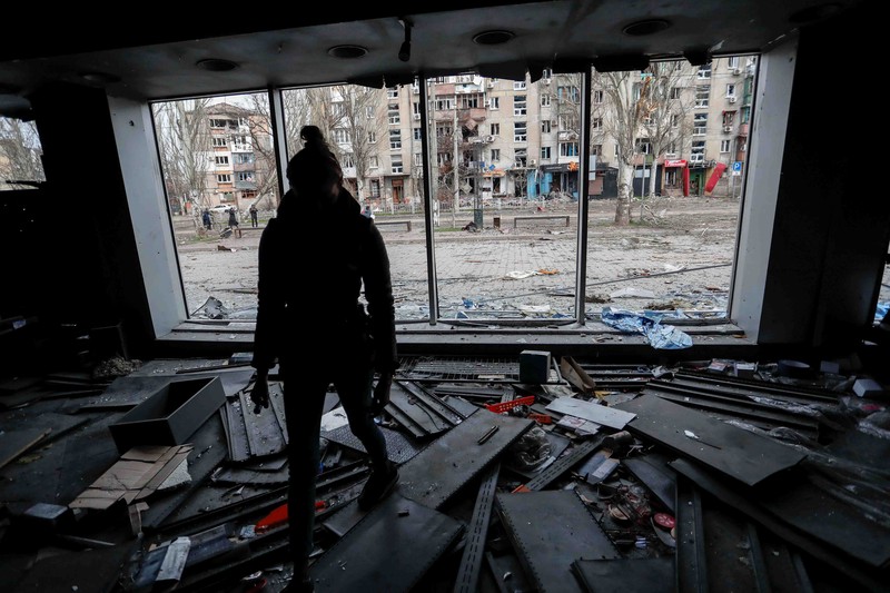 Service members of pro-Russian troops and civilians sit atop of an armoured vehicle during Ukraine-Russia conflict in the southern port city of Mariupol, Ukraine April 17, 2022. REUTERS/Alexander Ermochenko