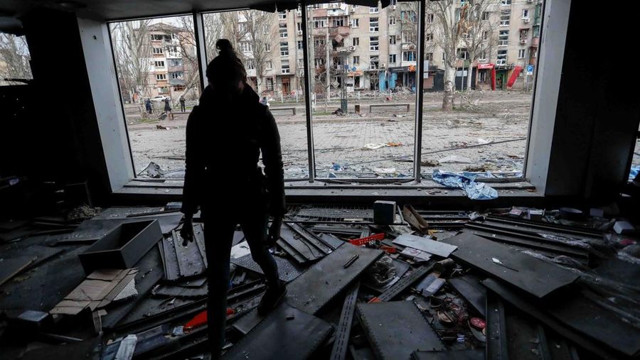 A woman walks inside a building, which was damaged during Ukraine-Russia conflict in the southern port city of Mariupol, Ukraine April 17, 2022. REUTERS/Alexander Ermochenko
