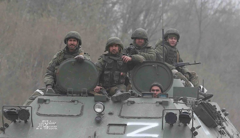 Service members of pro-Russian troops and civilians sit atop of an armoured vehicle during Ukraine-Russia conflict in the southern port city of Mariupol, Ukraine April 17, 2022. REUTERS/Alexander Ermochenko