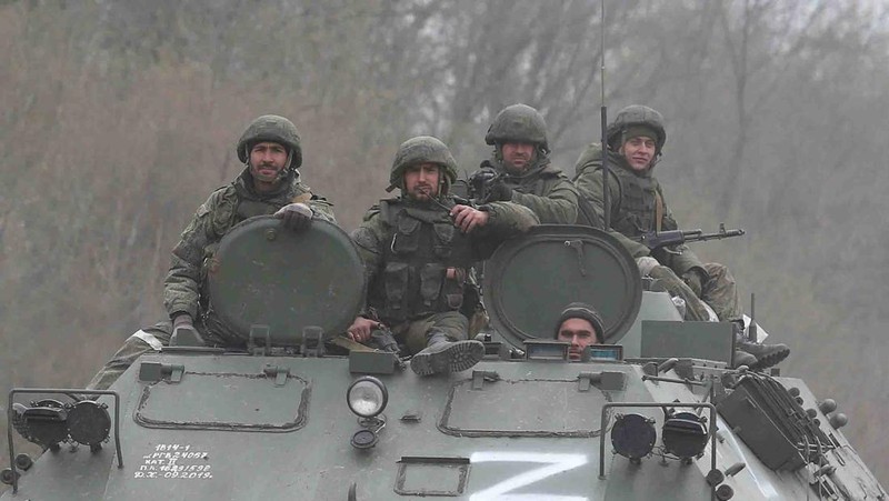 Service members of pro-Russian troops and civilians sit atop of an armoured vehicle during Ukraine-Russia conflict in the southern port city of Mariupol, Ukraine April 17, 2022. REUTERS/Alexander Ermochenko