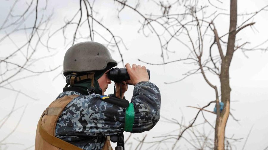 A Ukrainian serviceman looks on with a binocular, as Russia's attack on Ukraine continues, at a position in Donetsk Region, Ukraine April 18, 2022.  REUTERS/Serhii Nuzhnenko