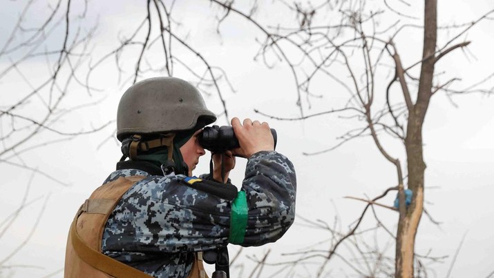 A Ukrainian serviceman looks on with a binocular, as Russia's attack on Ukraine continues, at a position in Donetsk Region, Ukraine April 18, 2022.  REUTERS/Serhii Nuzhnenko