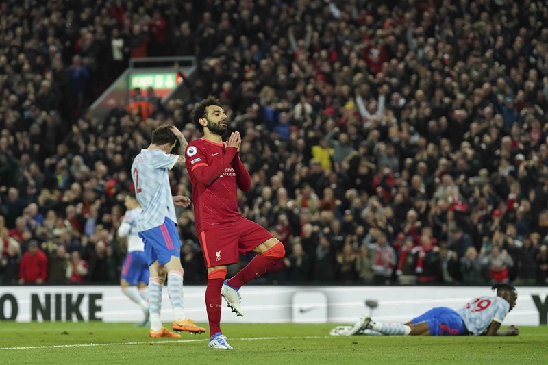Britain Soccer Premier League Liverpool's Mohamed Salah, fifth left, celebrates with his teammates after scoring his side's second goal during the English Premier League soccer match between Liverpool and Manchester United at Anfield stadium in Liverpool, England, Tuesday, April 19, 2022. (AP Photo/Jon Super)