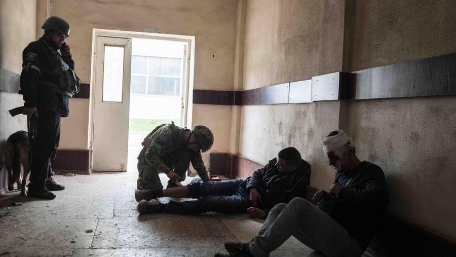 A member of security forces gives first aid to an injured man following a Russian bombing of a factory in Kramatorsk, eastern Ukraine, Tuesday, April 19, 2022, killing at least one person and injuring three others. Russian forces attacked along a broad front in eastern Ukraine on Tuesday as part of a full-scale ground offensive to take control of the country's eastern industrial heartland in what Ukrainian officials called a 