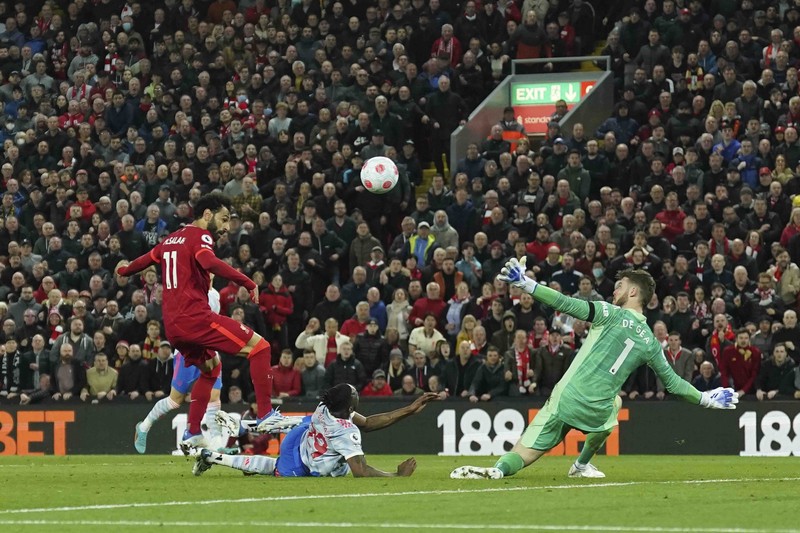Britain Soccer Premier League Liverpool's Mohamed Salah, fifth left, celebrates with his teammates after scoring his side's second goal during the English Premier League soccer match between Liverpool and Manchester United at Anfield stadium in Liverpool, England, Tuesday, April 19, 2022. (AP Photo/Jon Super)