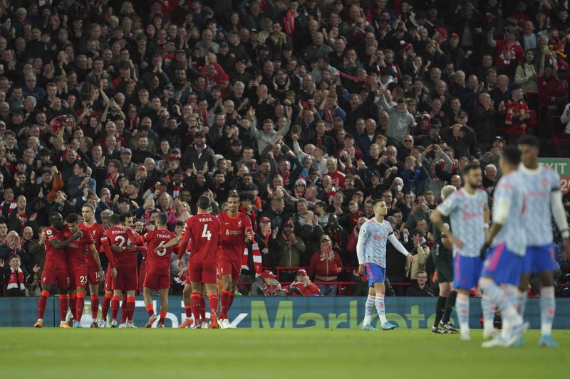 Britain Soccer Premier League Liverpool's Mohamed Salah, fifth left, celebrates with his teammates after scoring his side's second goal during the English Premier League soccer match between Liverpool and Manchester United at Anfield stadium in Liverpool, England, Tuesday, April 19, 2022. (AP Photo/Jon Super)