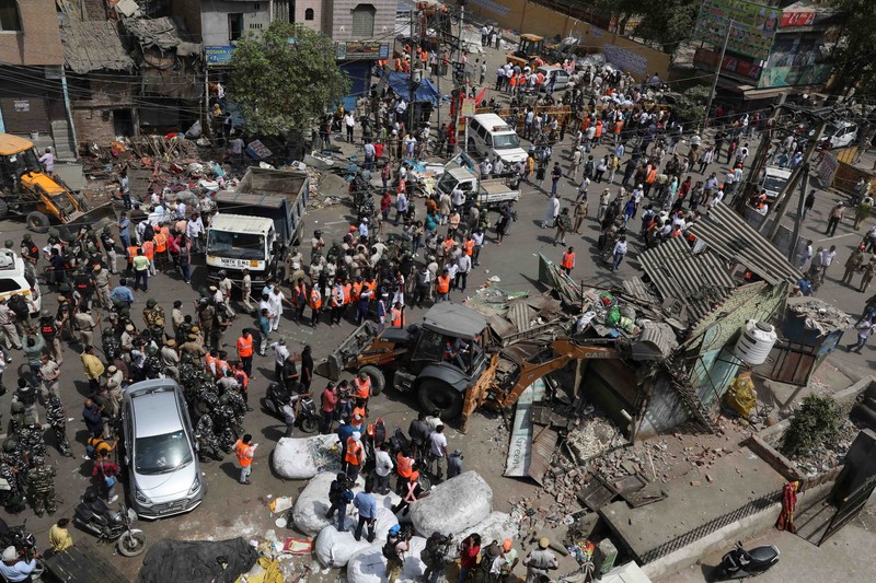 People watch the demolition of small illegal retail shops in a communally sensitive area in Jahangirpuri, in New Delhi, India, April 20, 2022. REUTERS/ Anushree Fadnavis