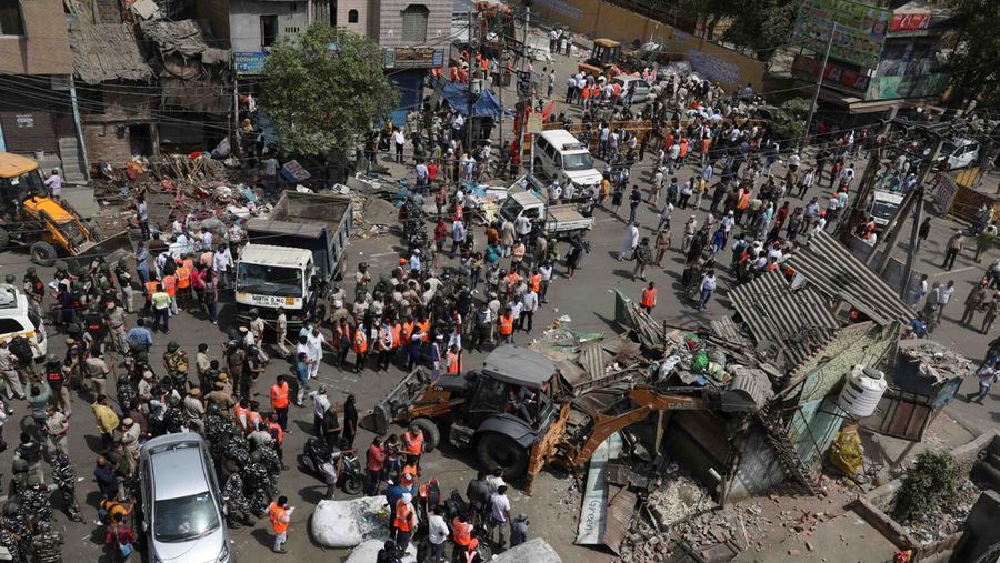 People watch the demolition of small illegal retail shops in a communally sensitive area in Jahangirpuri, in New Delhi, India, April 20, 2022. REUTERS/ Anushree Fadnavis