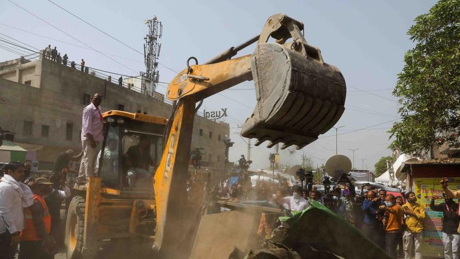 People watch the demolition of small illegal retail shops in a communally sensitive area in Jahangirpuri, in New Delhi, India, April 20, 2022. REUTERS/ Anushree Fadnavis
