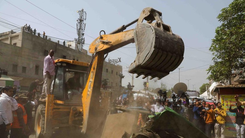People watch the demolition of small illegal retail shops in a communally sensitive area in Jahangirpuri, in New Delhi, India, April 20, 2022. REUTERS/ Anushree Fadnavis