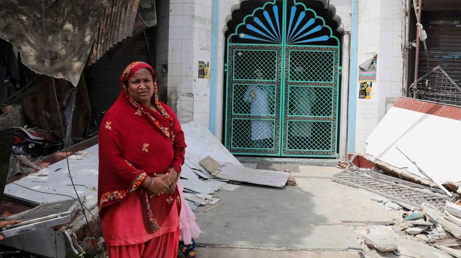 People from inside the mosque watch the demolition of small illegal retail shops in a communally sensitive area in Jahangirpuri, in New Delhi, India, April 20, 2022. REUTERS/ Anushree Fadnavis