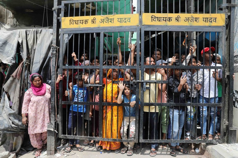 People watch the demolition of small illegal retail shops in a communally sensitive area in Jahangirpuri, in New Delhi, India, April 20, 2022. REUTERS/ Anushree Fadnavis