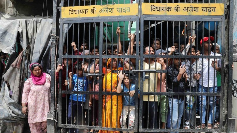 People watch the demolition of small illegal retail shops in a communally sensitive area in Jahangirpuri, in New Delhi, India, April 20, 2022. REUTERS/ Anushree Fadnavis