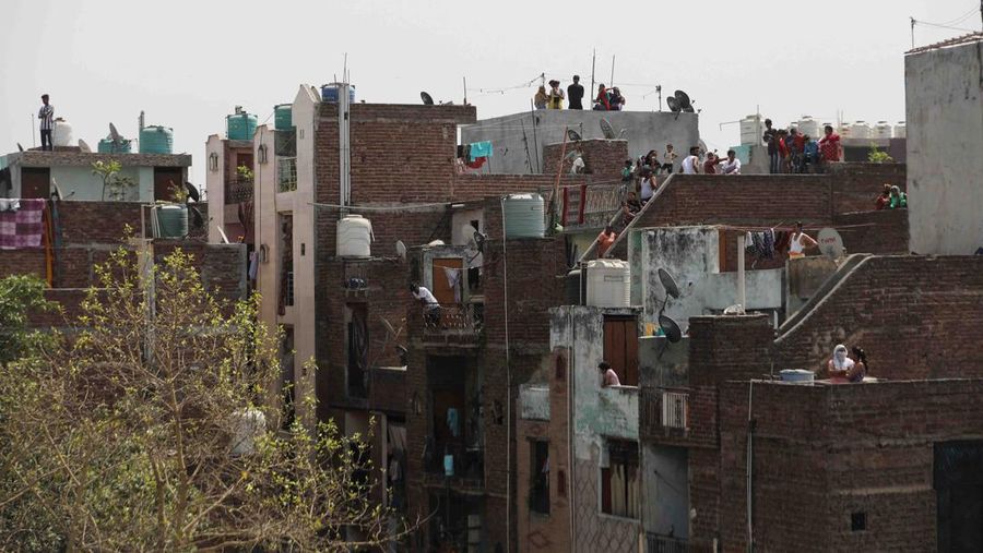 People watch the demolition of small illegal retail shops in a communally sensitive area in Jahangirpuri, in New Delhi, India, April 20, 2022. REUTERS/ Anushree Fadnavis
