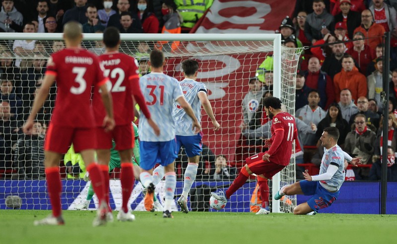 Britain Soccer Premier League Liverpool's Mohamed Salah, fifth left, celebrates with his teammates after scoring his side's second goal during the English Premier League soccer match between Liverpool and Manchester United at Anfield stadium in Liverpool, England, Tuesday, April 19, 2022. (AP Photo/Jon Super)
