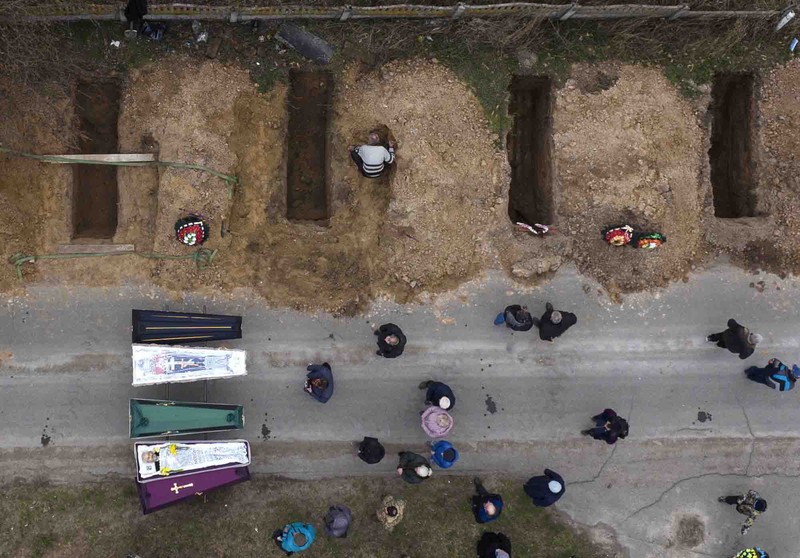 A general view of the cemetery in Irpin where three dug graves await the next funerals on Tuesday, April 19, 2022, in the outskirts of Kyiv. (AP Photo/Emilio Morenatti)