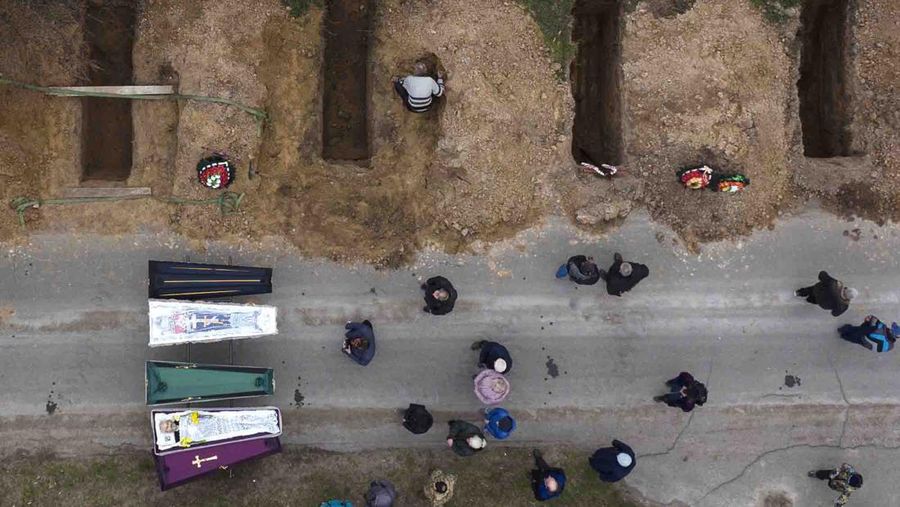 A general view of the cemetery in Irpin where three dug graves await the next funerals on Tuesday, April 19, 2022, in the outskirts of Kyiv. (AP Photo/Emilio Morenatti)