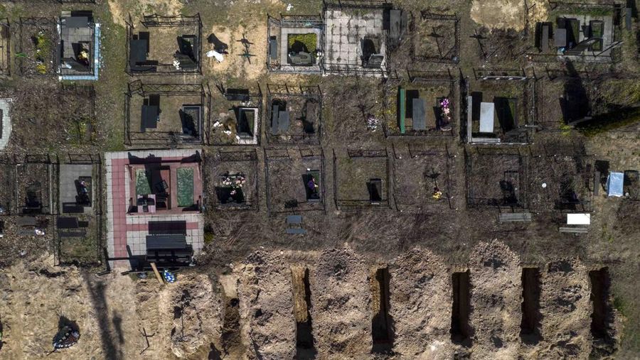 A general view of the cemetery in Irpin where three dug graves await the next funerals on Tuesday, April 19, 2022, in the outskirts of Kyiv. (AP Photo/Emilio Morenatti)