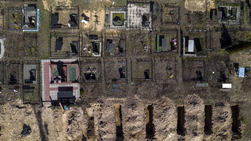 A general view of the cemetery in Irpin where three dug graves await the next funerals on Tuesday, April 19, 2022, in the outskirts of Kyiv. (AP Photo/Emilio Morenatti)