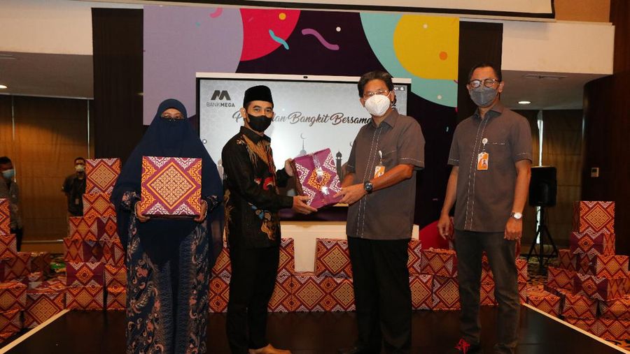 Direktur Utama Bank Mega (kedua dari kanan) menyerahkan bantuan sembako Program Mega Peduli di Menara Bank Mega, Jakarta, Jumat (22/4/2022).