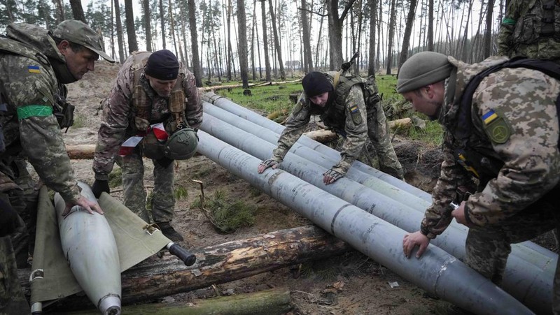 Ukrainian soldiers examine Russian multiple missiles abandoned by Russian troops, in the village of Berezivka, Ukraine, Thursday, April 21, 2022. (AP Photo/Efrem Lukatsky)