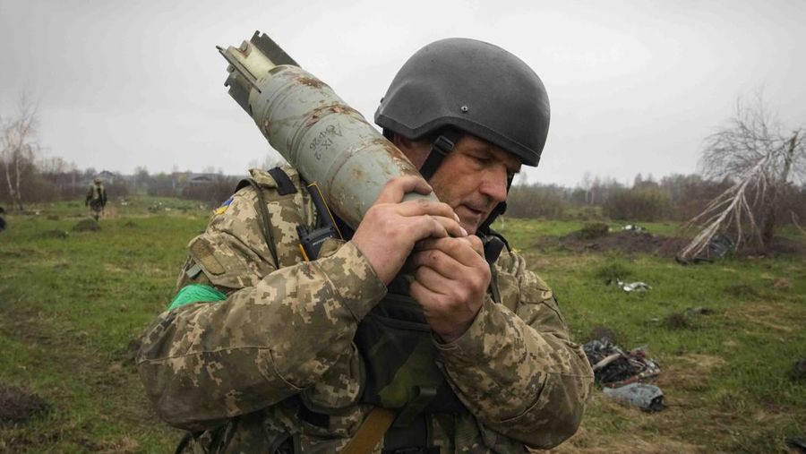 Ukrainian soldiers examine Russian multiple missiles abandoned by Russian troops, in the village of Berezivka, Ukraine, Thursday, April 21, 2022. (AP Photo/Efrem Lukatsky)