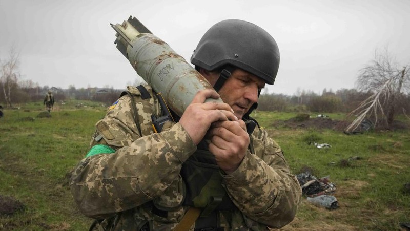 Ukrainian soldiers examine Russian multiple missiles abandoned by Russian troops, in the village of Berezivka, Ukraine, Thursday, April 21, 2022. (AP Photo/Efrem Lukatsky)
