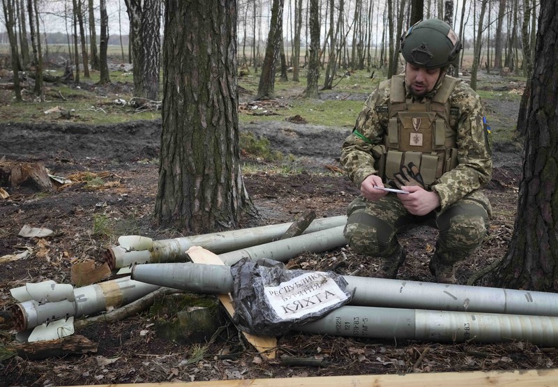Ukrainian soldiers examine Russian multiple missiles abandoned by Russian troops, in the village of Berezivka, Ukraine, Thursday, April 21, 2022. (AP Photo/Efrem Lukatsky)