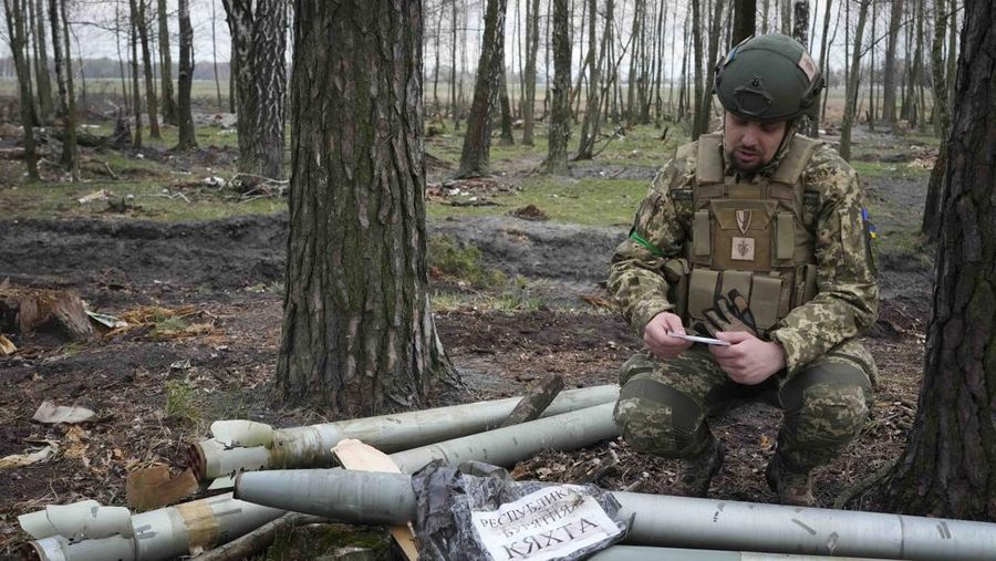 Ukrainian soldiers examine Russian multiple missiles abandoned by Russian troops, in the village of Berezivka, Ukraine, Thursday, April 21, 2022. (AP Photo/Efrem Lukatsky)