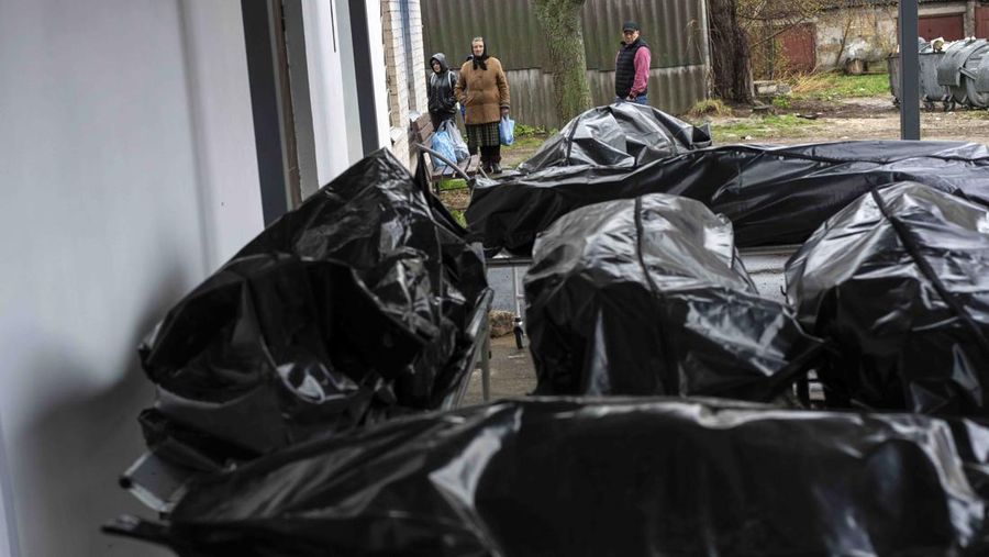A general view of the cemetery in Irpin where three dug graves await the next funerals on Tuesday, April 19, 2022, in the outskirts of Kyiv. (AP Photo/Emilio Morenatti)