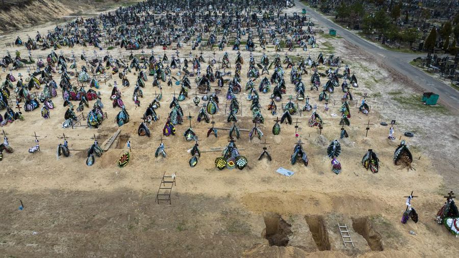 A general view of the cemetery in Irpin where three dug graves await the next funerals on Tuesday, April 19, 2022, in the outskirts of Kyiv. (AP Photo/Emilio Morenatti)