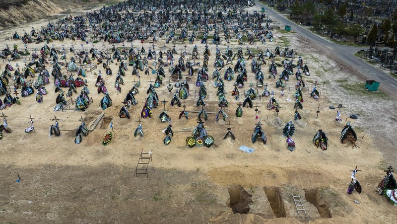 A general view of the cemetery in Irpin where three dug graves await the next funerals on Tuesday, April 19, 2022, in the outskirts of Kyiv. (AP Photo/Emilio Morenatti)