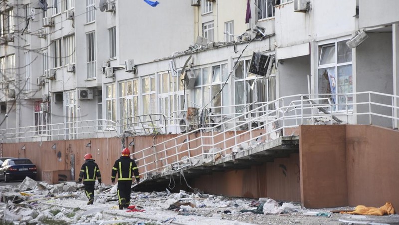 Petugas pemadam kebakaran berjalan melewati sebuah gedung apartemen yang rusak akibat serangan rudal Rusia di Odesa, Ukraina, Sabtu (23/4/2022). Rusia menembakkan sedikitnya enam rudal jelajah ke kota pelabuhan Laut Hitam Odesa yang menewaskan lima orang. (AP Photo/Max Pshybyshevsky)