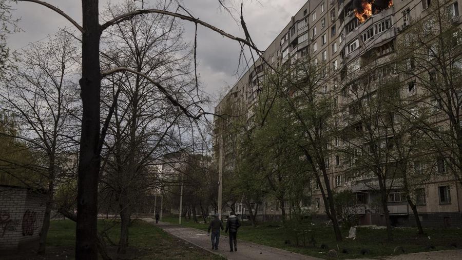 Petugas pemadam kebakaran berjalan melewati sebuah gedung apartemen yang rusak akibat serangan rudal Rusia di Odesa, Ukraina, Sabtu (23/4/2022). Rusia menembakkan sedikitnya enam rudal jelajah ke kota pelabuhan Laut Hitam Odesa yang menewaskan lima orang. (AP Photo/Max Pshybyshevsky)