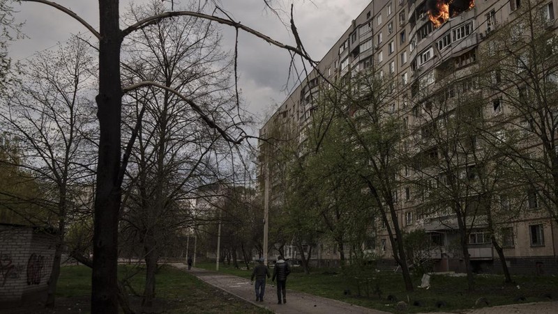 Petugas pemadam kebakaran berjalan melewati sebuah gedung apartemen yang rusak akibat serangan rudal Rusia di Odesa, Ukraina, Sabtu (23/4/2022). Rusia menembakkan sedikitnya enam rudal jelajah ke kota pelabuhan Laut Hitam Odesa yang menewaskan lima orang. (AP Photo/Max Pshybyshevsky)