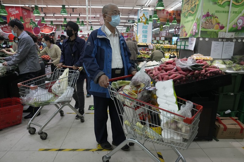 Kenaikan kasus Covid-19 di ibu kota China, Beijing, mendorong kekhawatiran akan penguncian (lockdown) yang ketat. Hal ini memicu panic buying di kalangan warga. (AP/Andy Wong)